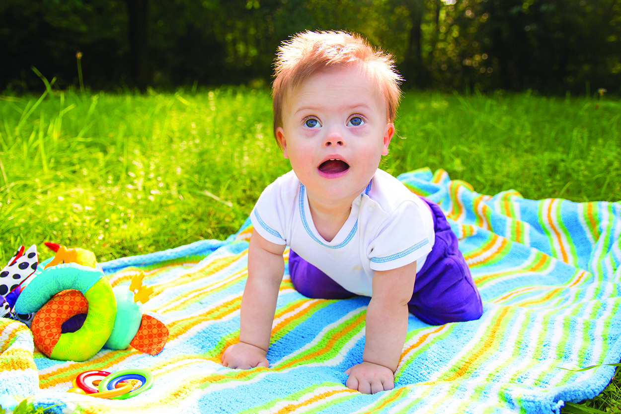 A child crawling on a blanket outside