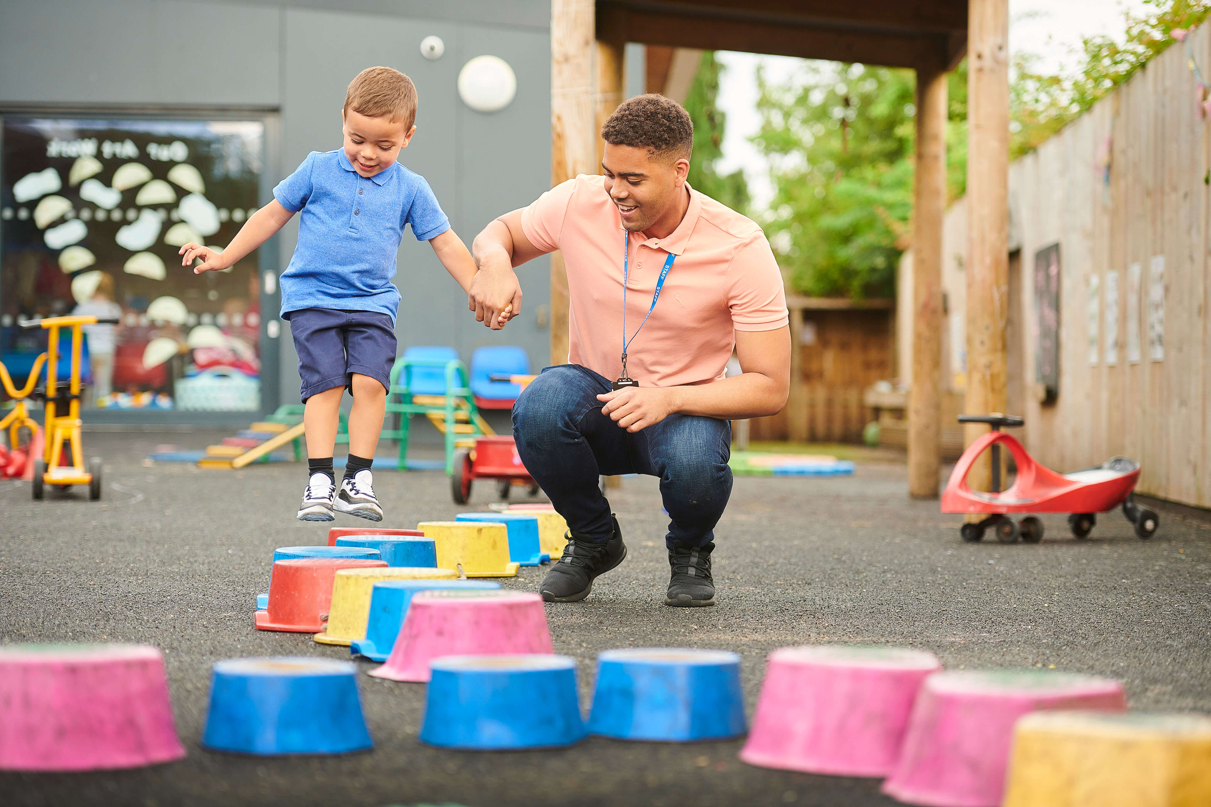 A male teacher helping student jump 