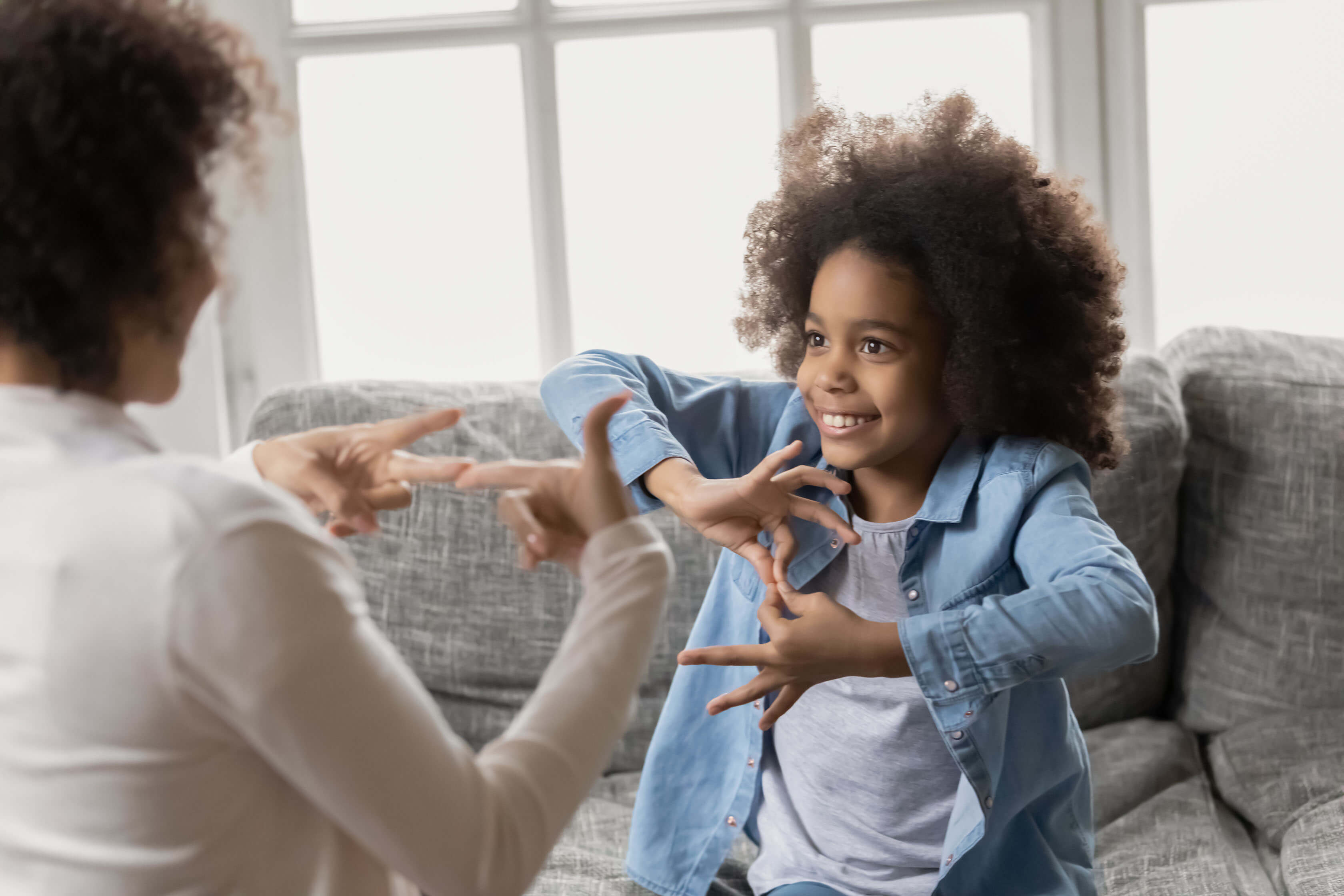 A young girl and woman using sign language