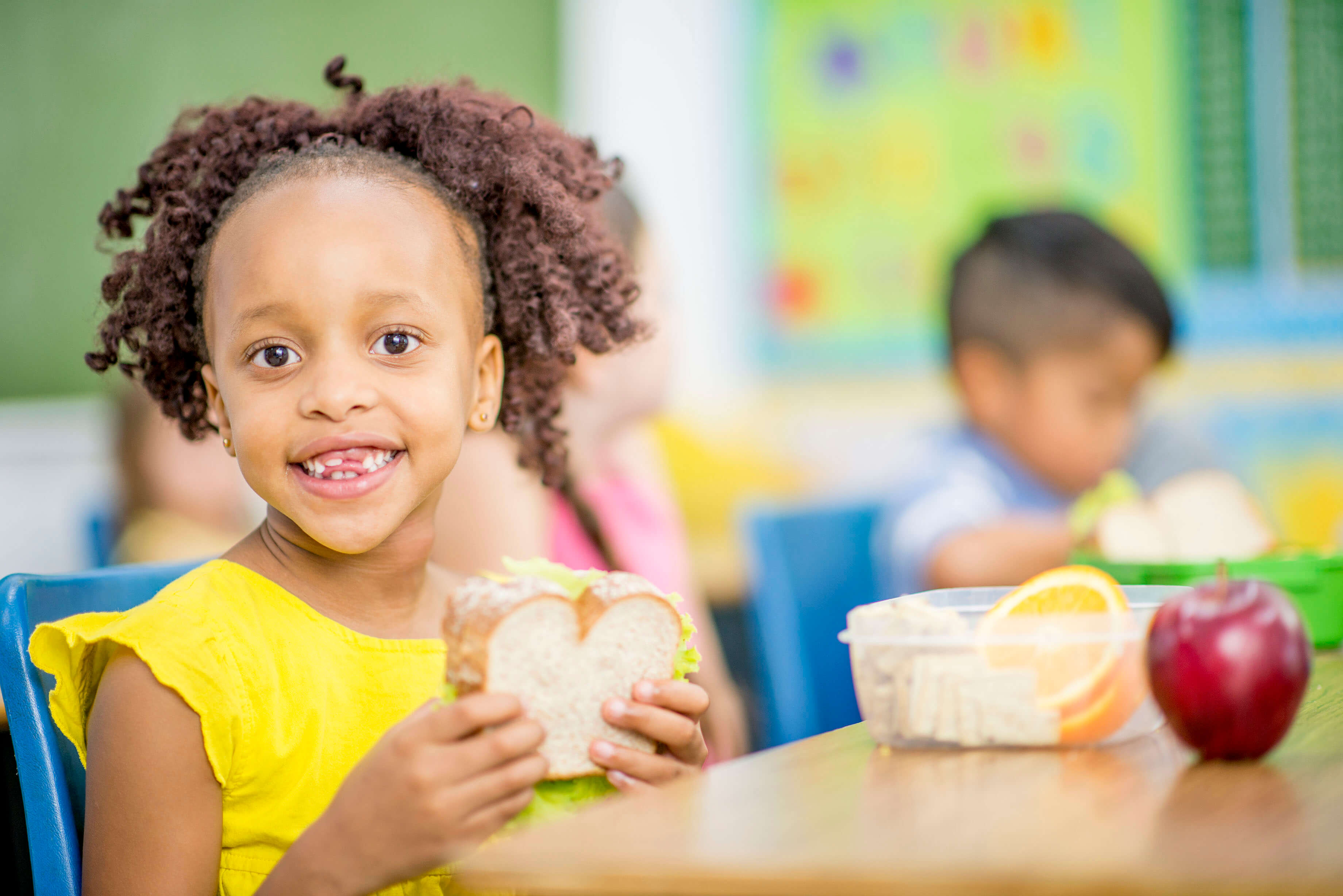 A girl eating her sandwich at her desk